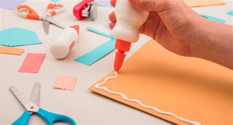 Free Photo Human Hand Applying White Glue On Orange Paper With