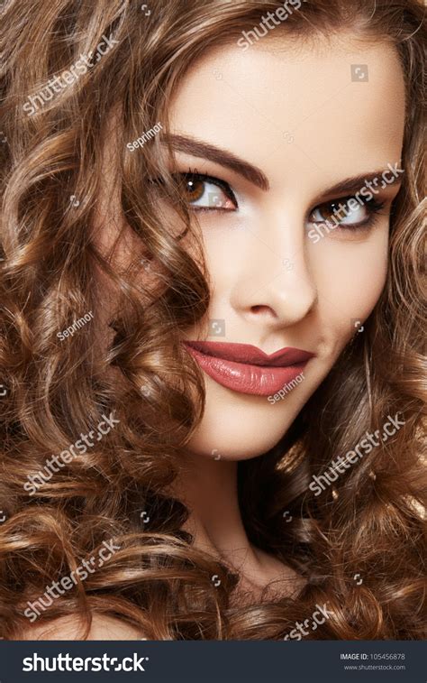 Lovely Model With Shiny Volume Curly Hair Pin Up Style On Beige