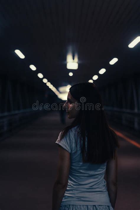 Portrait Of Young Woman Walks Alone In A Dark Tunnel Girl Look Back In