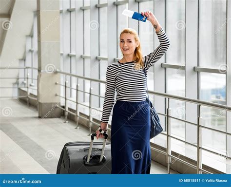 femme parlant sur la station avec une valise et un sac à dos et tenant un passeport dans leurs
