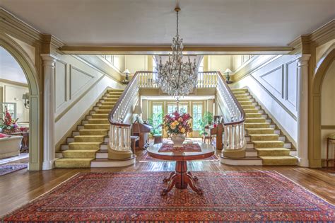 A Foyer With Chandelier And Stairs Leading Up To The Second Floor