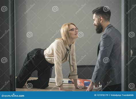 sexual flirt at work secretary seduce boss in office businesswoman on desktop look at bearded