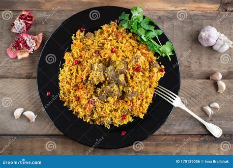 Dish Of Oriental Cuisine Pilaf With Lamb In A Pan On A Wooden