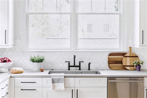 Bright Kitchen Features White Cabinets A Mosaic Backsplash And Black