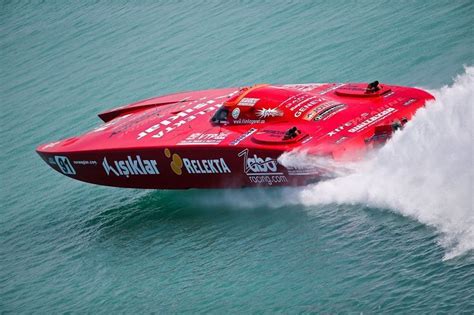 A Red Speed Boat Speeding Across The Water
