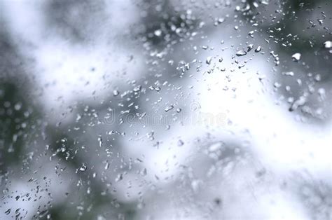 A Photo Of Rain Drops On The Window Glass With A Blurred View Of The