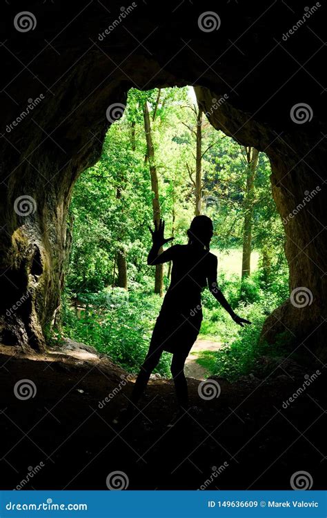 Girl S Silhouette At The Entrance To Natural Cave In The Forrest Stock
