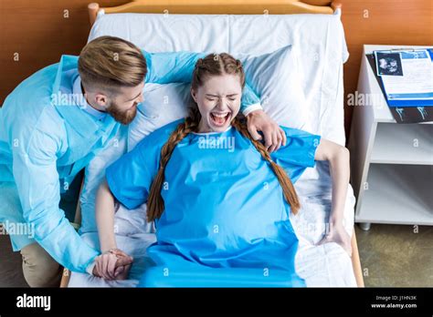 Pregnant Woman Giving Birth In Hospital While Man Hugging Her Stock Photo Alamy