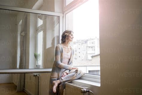 Mature Woman Looking Out Of Window Stock Photo