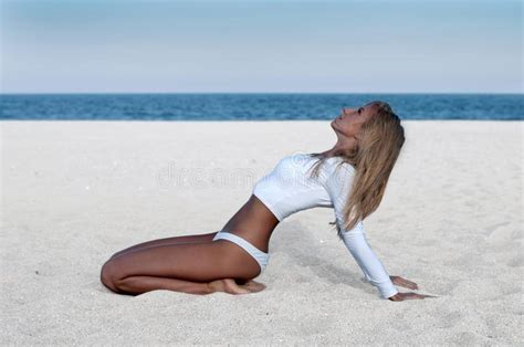 Beautiful Tanned Woman In A White Swimsuit On The Beach Stock Image