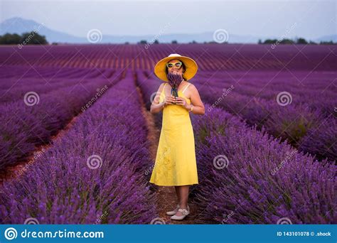 Asian Woman In Yellow Dress And Hat At Lavender Field Stock Photo