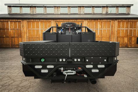 The Back End Of A Large Truck Parked In Front Of A Wooden Building With