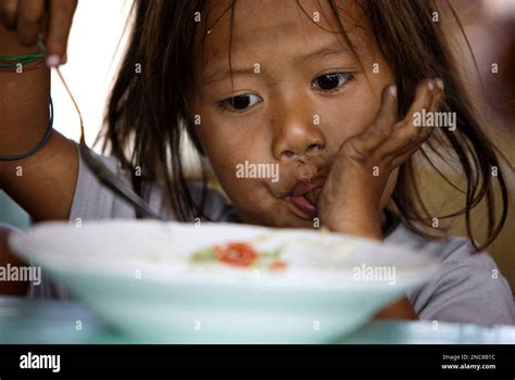 A Filipino Girl Sucks Her Thumb As She Finishes The Porridge That Was