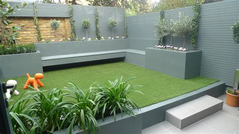 That's why it's good to look for shrubs and trees that max out interest as they grow up, not out. Modern small low maintenance garden fake grass grey raised beds contemporary planting Battersea ...