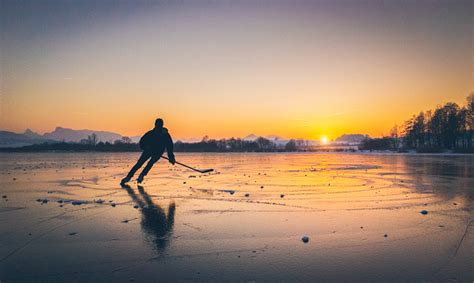 Hockey Player Skating On A Frozen Lake At Sunset Stock Photo Download