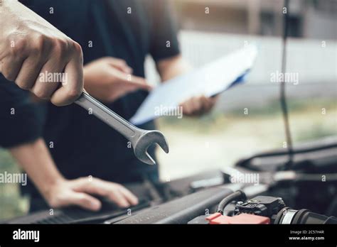 Car Mechanic Is Holding A Wrench Ready To Check The Engine And Maintain