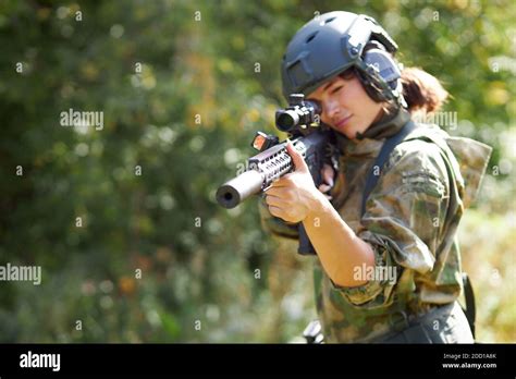 Sportive Caucasian Woman Soldier Shooting With Rifle Machine Gun In The