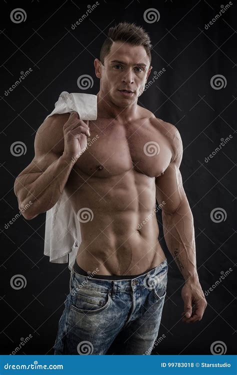 Male Bodybuilder Opening His Shirt Revealing Muscular Torso Stock Photo