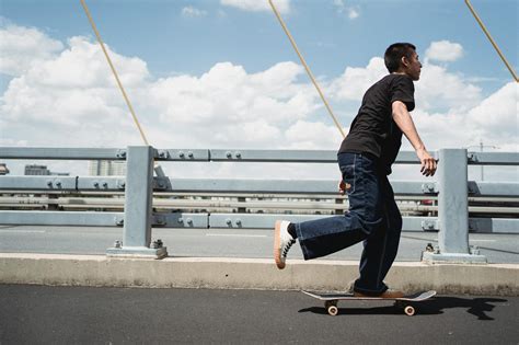 Active Man Riding Skateboard On City Bridge · Free Stock Photo
