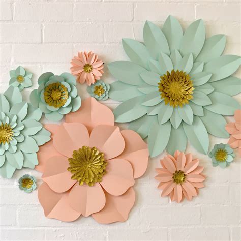 She uses a variety of colors to make four different flower types in all different sizes for a stunning display. handmade glitter centre paper flower wall display by may contain glitter | notonthehighstreet.com