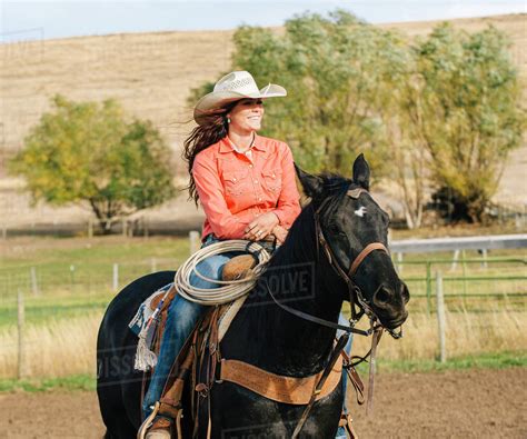 Caucasian Woman Riding Horse On Ranch Stock Photo Dissolve
