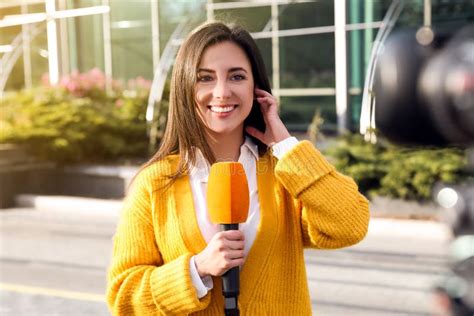 Young Female Journalist With Microphone Working On Street Stock Image
