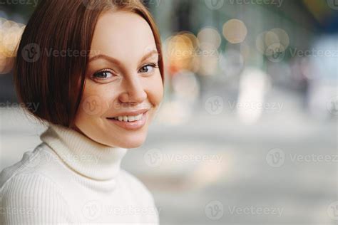 Sideways Shot Of Pleasant Looking Woman With Make Up Tender Smile