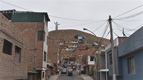A Statue Of Christ Looks Over Slum Buildings On The Outskirts Of Lima