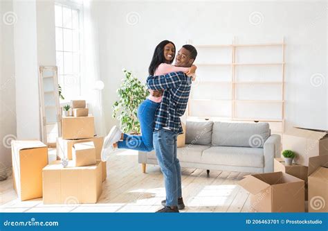 Happy Moving Day Loving Black Man Embracing And Lifting His Pretty