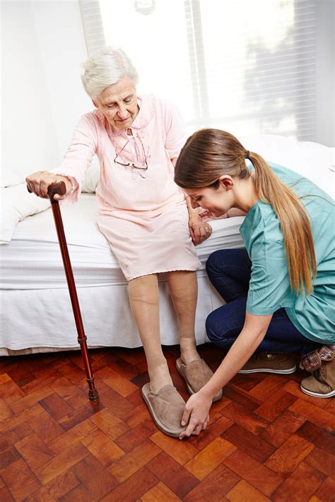 Altenpfleger hilft Seniorin beim Aufstehen - SOPHIA Südbayern gGmbH