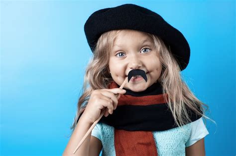 Premium Photo Funny Girl In Black Beret Scarf And Mustache On A Stick On Blue
