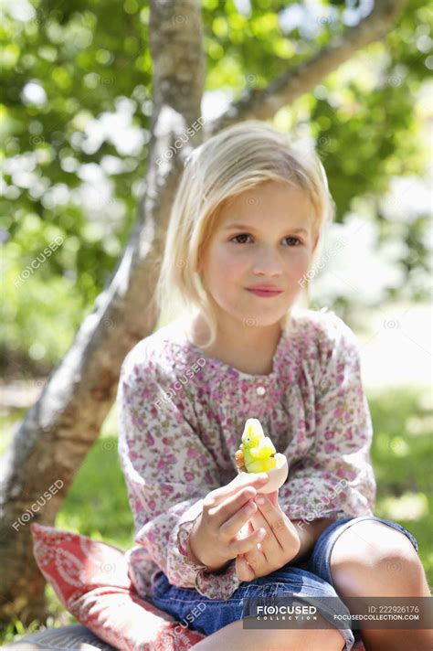 Cute Little Girl Holding Toy In Garden — Looking Away Tree Stock