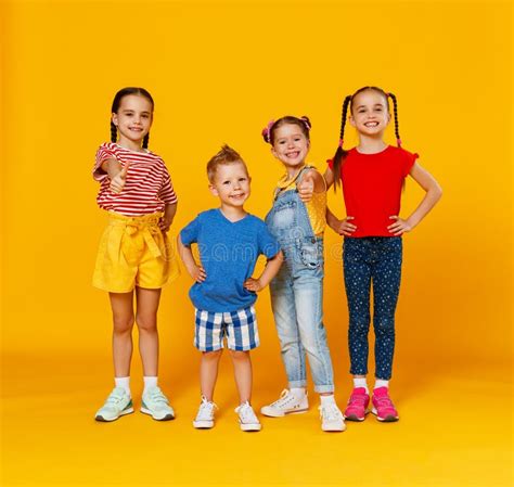Group Of Cheerful Happy Children On Colored Yellow Background Stock