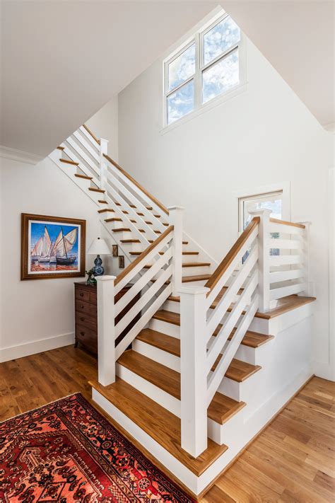 The wooden newel posts and treads are retained to maintain the rustic charm of the iconic style. Modern Farmhouse - Farmhouse - Staircase - Other - by CarsonSpeer Builders