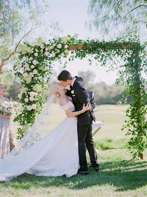 First Kiss Photo Under Greenery Covered Arch Outdoor Ceremony Rancho