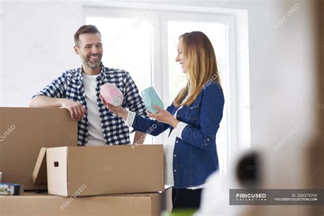 Couple Moving Into New Flat Packing Cardboard Boxes — Real Estate
