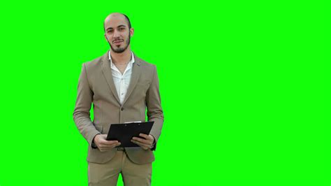 Smiling Young Man Making Business Presentation On A Green Screen
