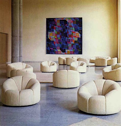 A Room With White Chairs And A Large Painting On The Wall Above Its