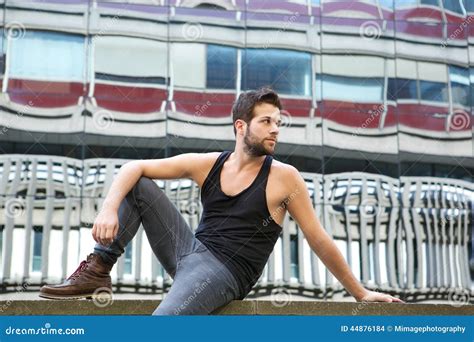 Male Fashion Model Sitting Outdoors In Urban Area Stock Photo Image