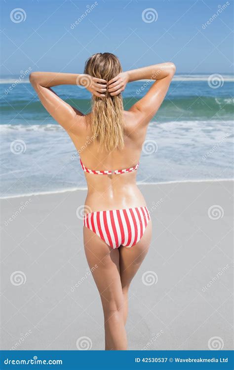 Donna Adatta Della Bionda In Bikini A Strisce Alla Spiaggia Immagine
