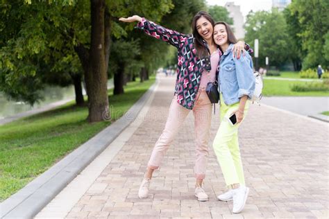 Two Cheerful Young Girls Walking In The Park Stock Photo Image Of