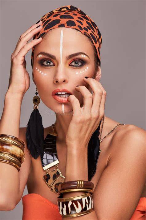 seductive beautiful woman wearing colorful shawl on head and accessories posing with hand on
