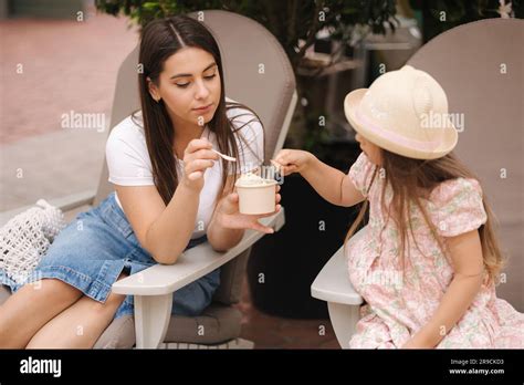 Petite fille mangeant de la crème glacée avec la mère Deux filles se
