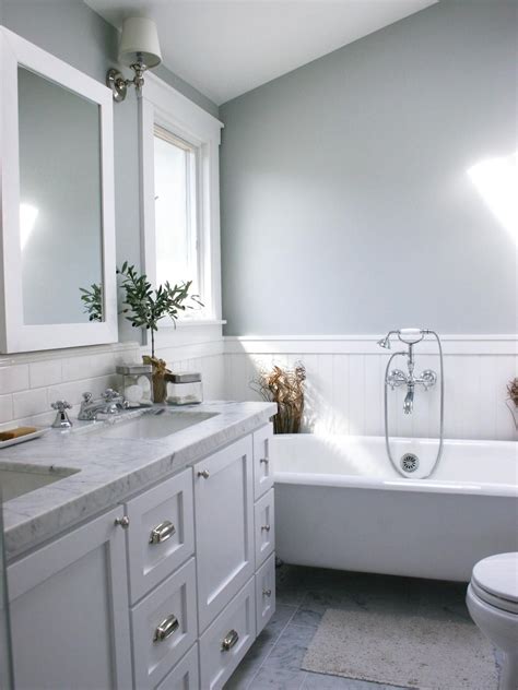 A White Bathtub Backsplash Tile Mirror And Window Frame Contrast With