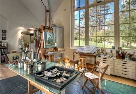 An Artist S Studio With Large Windows And Lots Of Art Supplies On The Table