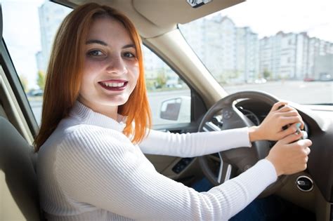 Premium Photo Young Redhead Woman Driver Behind A Wheel Driving A Car