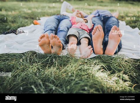 Feet Of A Boy Mom And Dad Lie On A White Bedspread Stock Photo Alamy