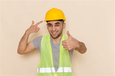 Free Photo Front View Male Builder In Yellow Helmet Posing With Smile On Light Background