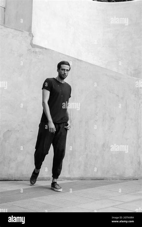 Full Length Portrait Of Young Man Standing Against Wall Stock Photo Alamy