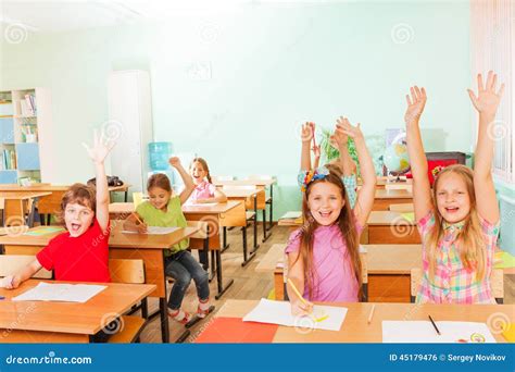 Happy Children With Arms Up Sitting In Classroom Stock Photo Image Of